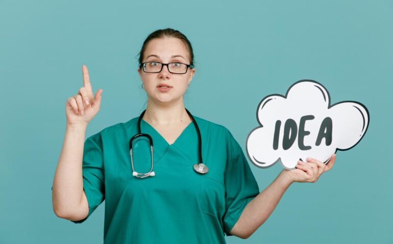young-woman-nurse-medical-uniform-with-stethoscope-around-neck-holding-bubble-speech-with-word-idea-looking-confident-showing-index-finger-standing-blue-background